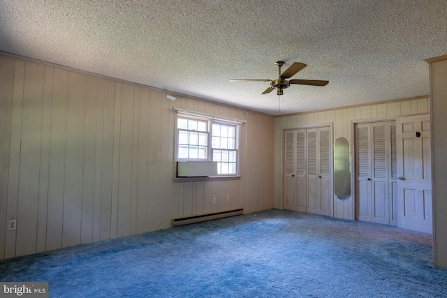 unfurnished bedroom with carpet flooring, ceiling fan, baseboard heating, a textured ceiling, and multiple closets