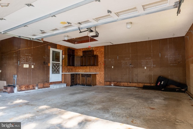 garage featuring wood walls and a garage door opener