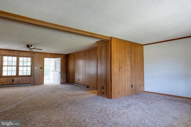 unfurnished living room with ceiling fan, a baseboard heating unit, wood walls, light carpet, and ornamental molding