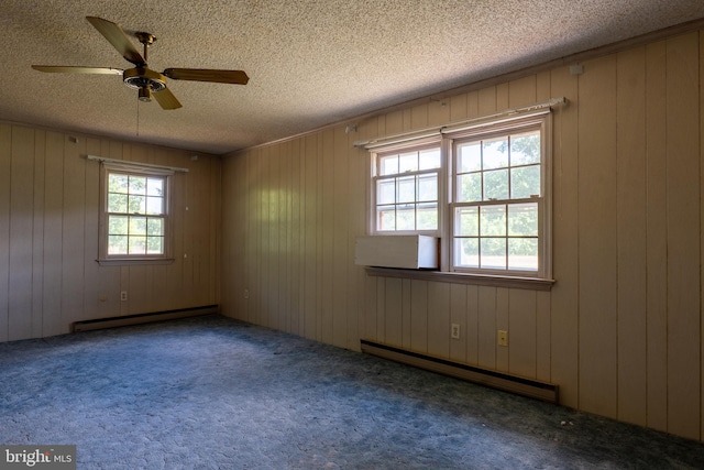 unfurnished room with baseboard heating, a wealth of natural light, and ceiling fan