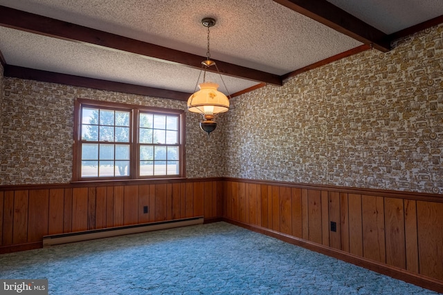 carpeted spare room with wooden walls, beamed ceiling, a textured ceiling, and a baseboard heating unit