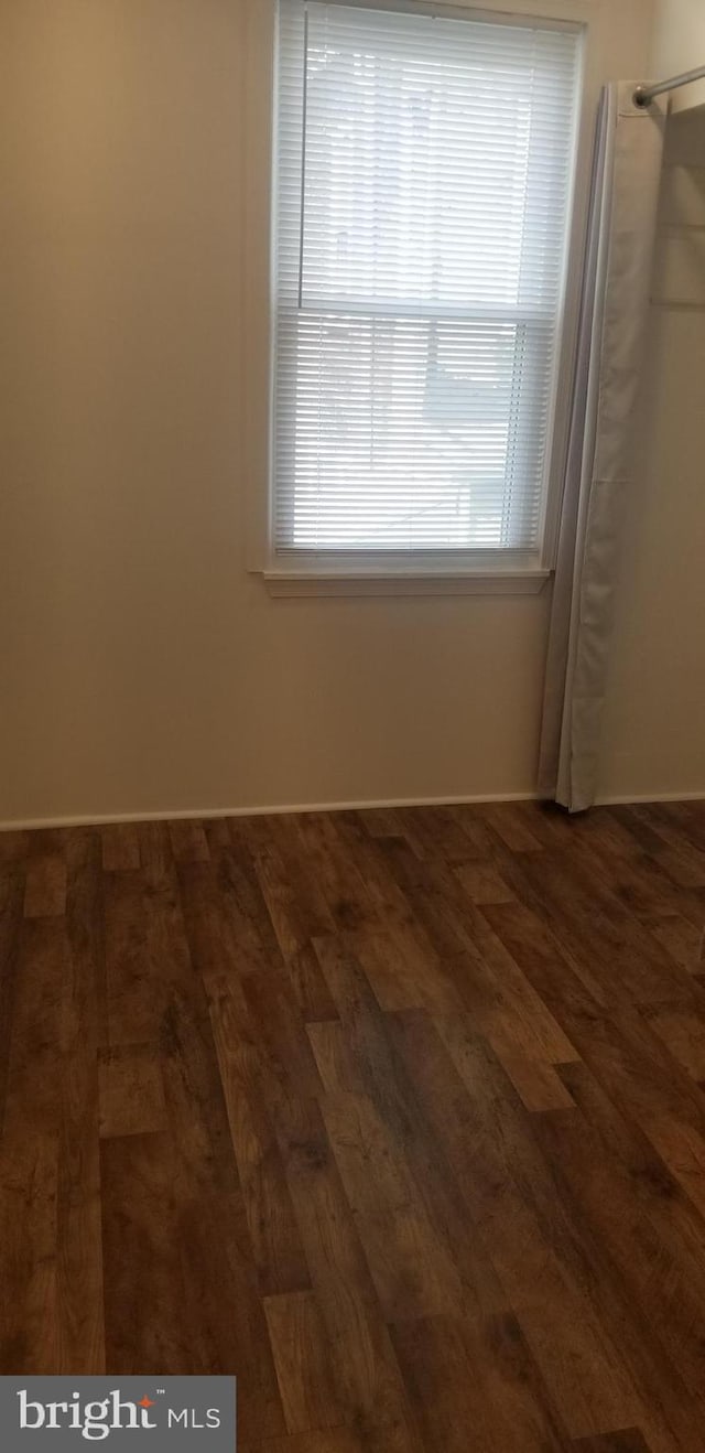 empty room with dark wood-type flooring