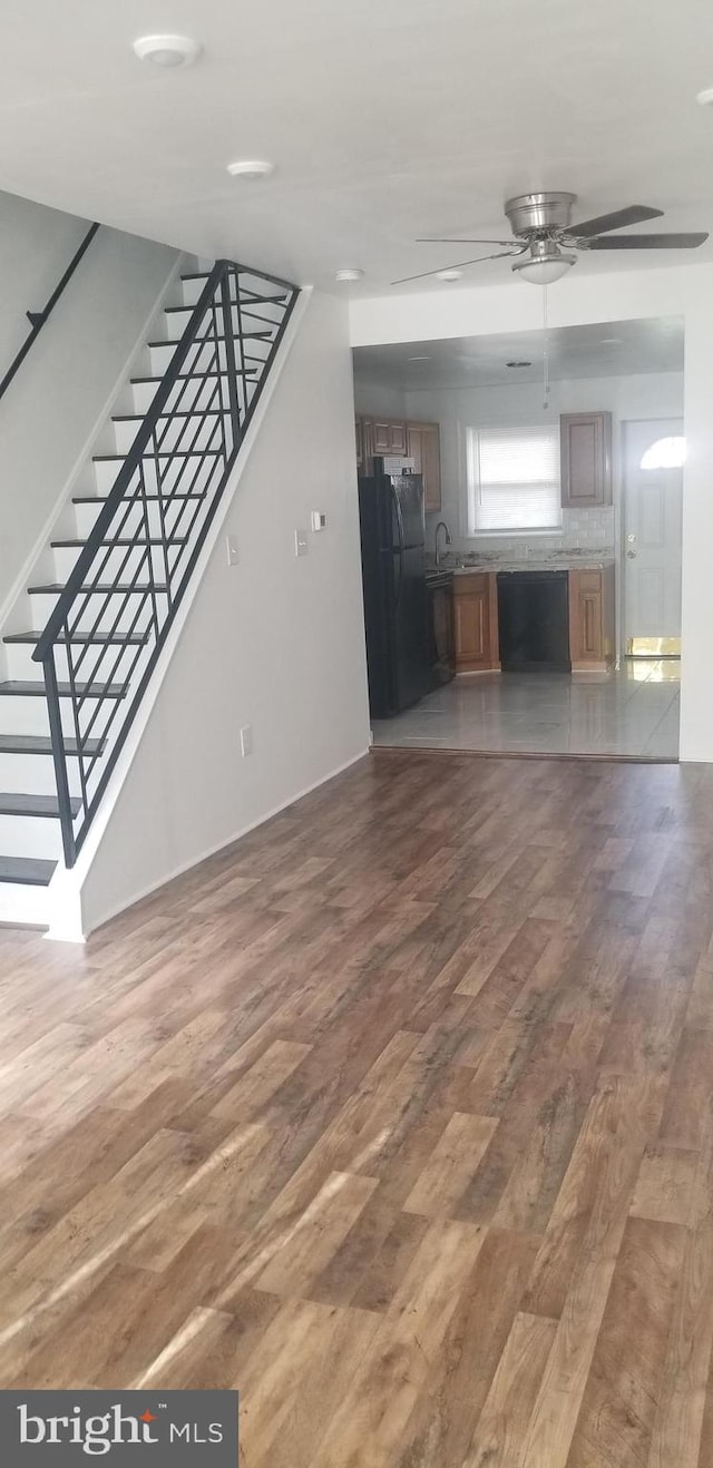 unfurnished living room featuring wood-type flooring and ceiling fan