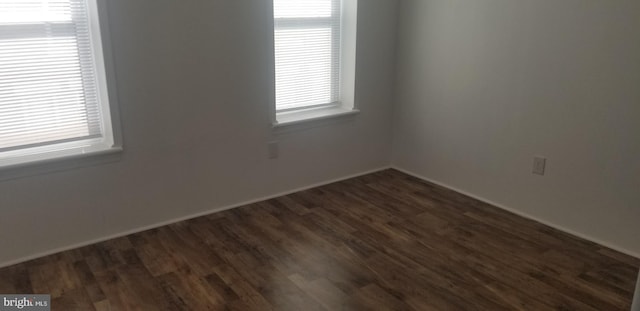 spare room with dark hardwood / wood-style flooring