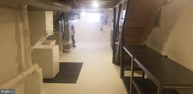 basement featuring stacked washing maching and dryer