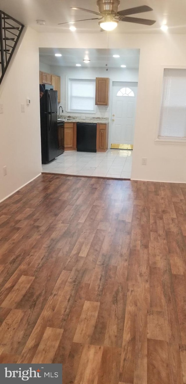 unfurnished living room featuring sink, ceiling fan, and light tile floors