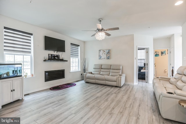 living room with a healthy amount of sunlight, light hardwood / wood-style flooring, and ceiling fan