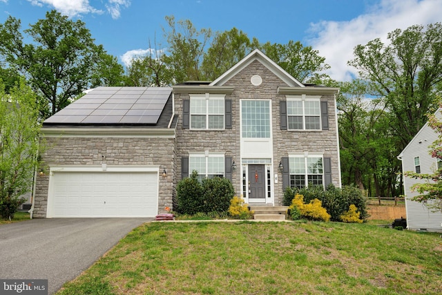 view of front of property featuring solar panels, a garage, and a front lawn