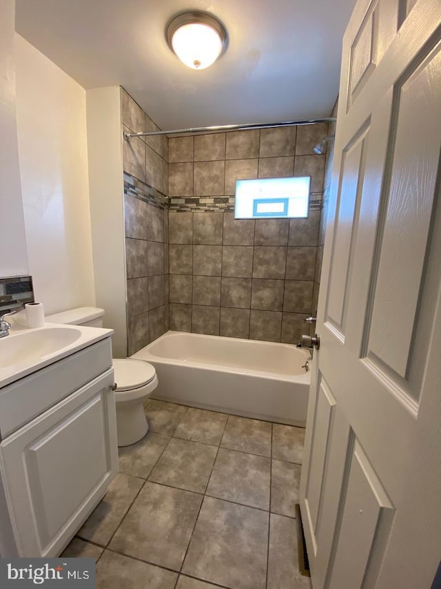 full bathroom with tile flooring, toilet, tiled shower / bath combo, and vanity