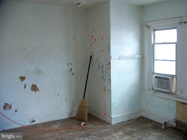 spare room featuring cooling unit and wood-type flooring