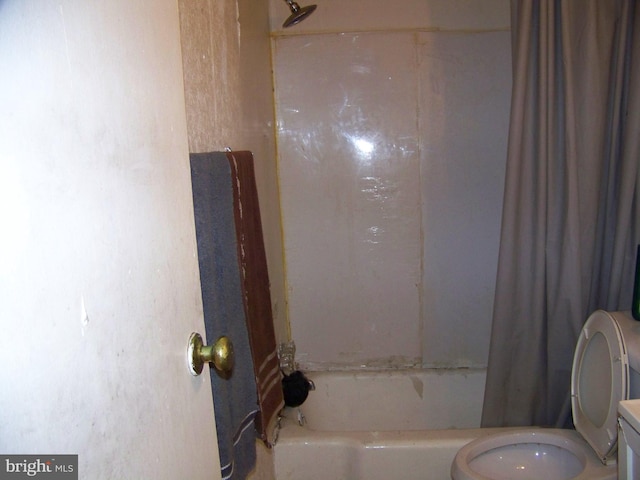 bathroom featuring shower / bath combination with curtain and toilet