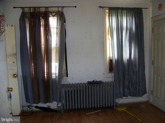 empty room with hardwood / wood-style flooring and radiator