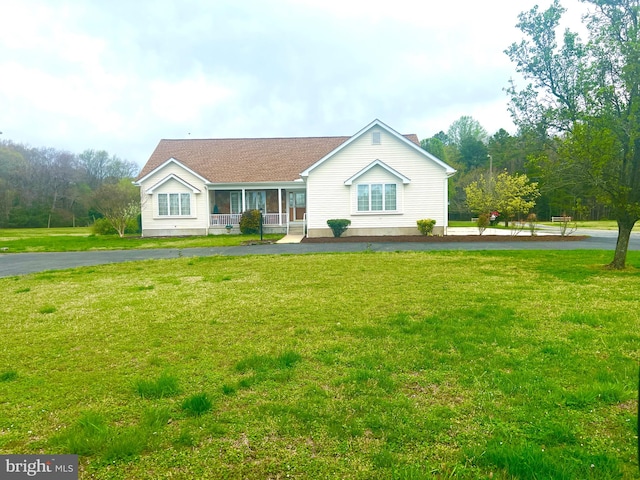 single story home featuring covered porch and a front lawn