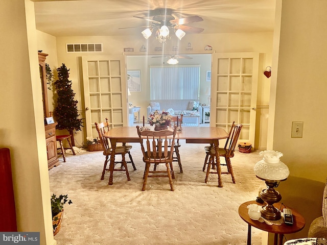 dining space featuring ceiling fan and carpet