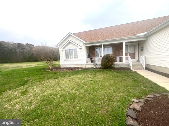 exterior space with covered porch, a shingled roof, and a lawn