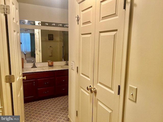 bathroom featuring a shower, a sink, and double vanity