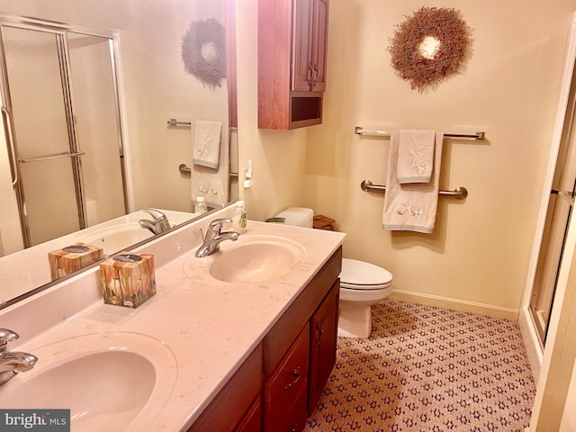 bathroom with vanity, toilet, and a shower with door