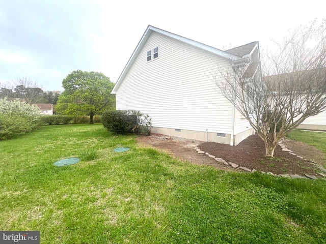 view of side of property featuring a yard and crawl space