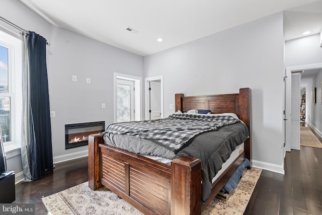 bedroom featuring dark hardwood / wood-style floors and multiple windows