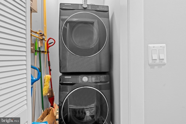 clothes washing area featuring stacked washing maching and dryer