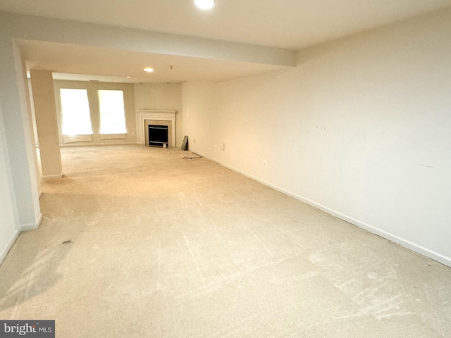 unfurnished living room featuring beam ceiling and light colored carpet