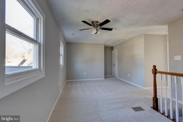 carpeted spare room with a textured ceiling and ceiling fan