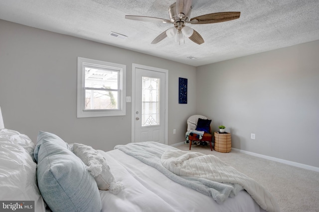 carpeted bedroom with a textured ceiling and ceiling fan