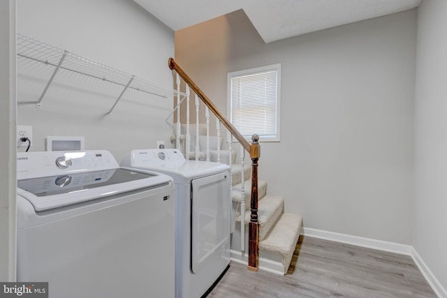 laundry room featuring separate washer and dryer and light wood-type flooring