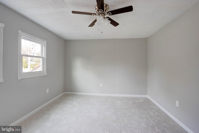 empty room featuring ceiling fan, carpet floors, and a textured ceiling