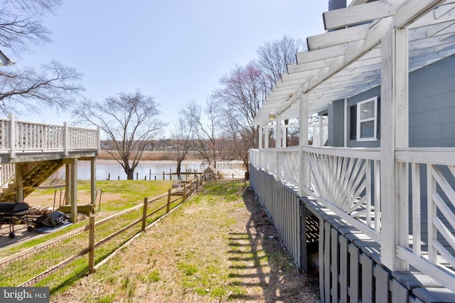 view of yard with a deck with water view