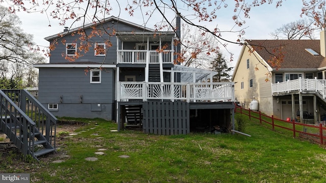 rear view of property featuring a lawn and a wooden deck