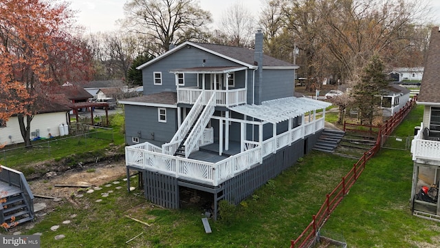 back of property with a sunroom and a wooden deck