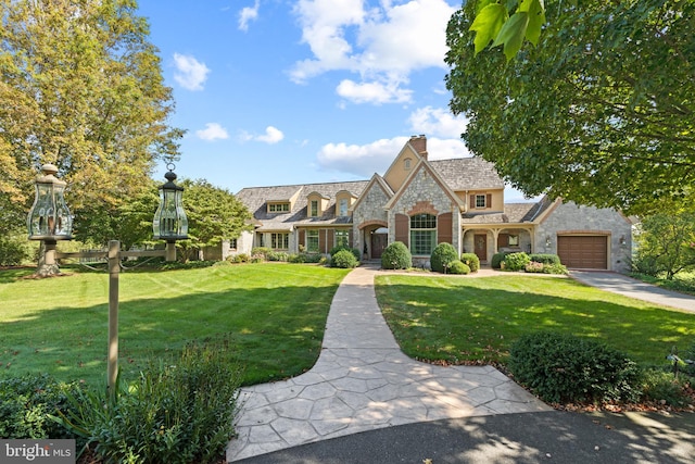 view of front of home with a garage and a front lawn