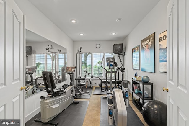 exercise room with a healthy amount of sunlight and dark carpet