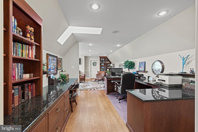 office area featuring vaulted ceiling with skylight and light wood-type flooring