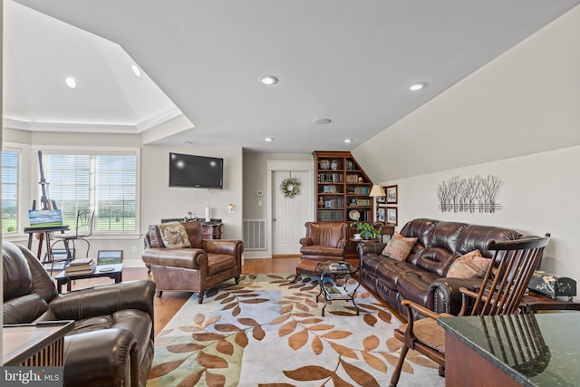 living room with light hardwood / wood-style floors and a tray ceiling