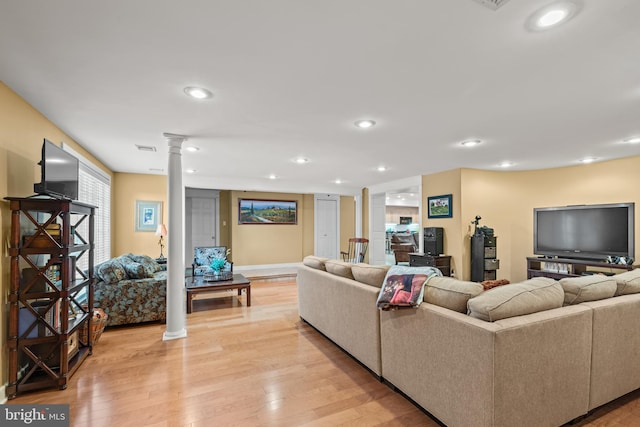 living room with light hardwood / wood-style flooring and decorative columns