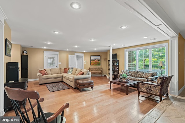 living room featuring ornate columns and light wood-type flooring