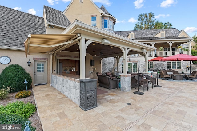 exterior space with an outdoor living space, ceiling fan, and a patio