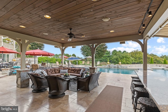 view of terrace with an outdoor living space, ceiling fan, and a fenced in pool