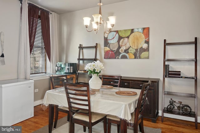 dining room with hardwood / wood-style floors and a notable chandelier