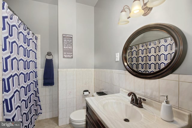 bathroom with vanity, tile walls, and toilet