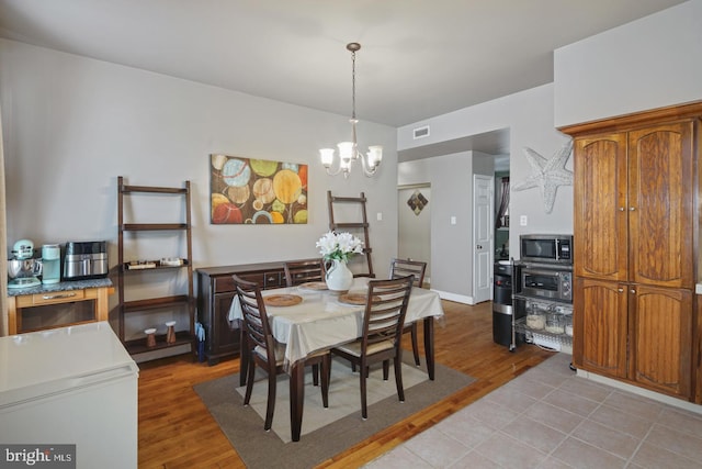 dining room featuring light hardwood / wood-style floors and an inviting chandelier