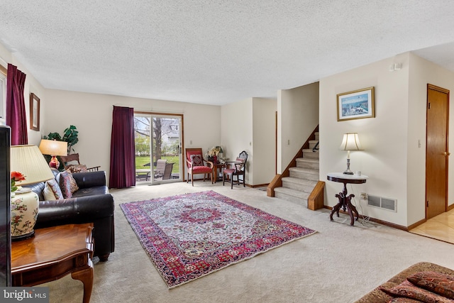 carpeted living room featuring a textured ceiling