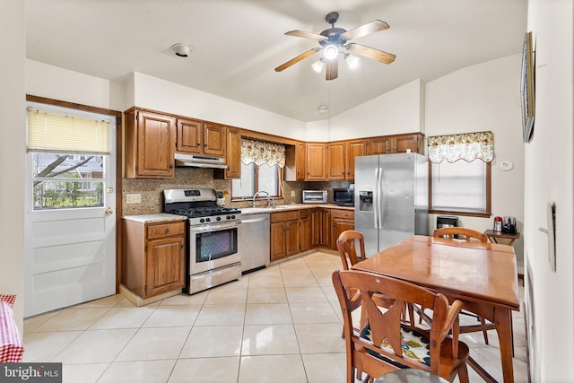 kitchen featuring appliances with stainless steel finishes, vaulted ceiling, tasteful backsplash, and ceiling fan