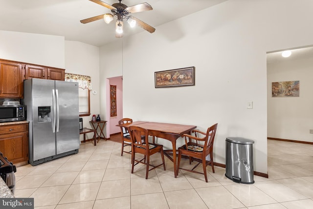 dining room featuring high vaulted ceiling, ceiling fan, and light tile floors