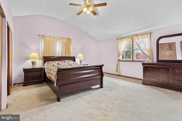 bedroom with light carpet, vaulted ceiling, ceiling fan, and a textured ceiling