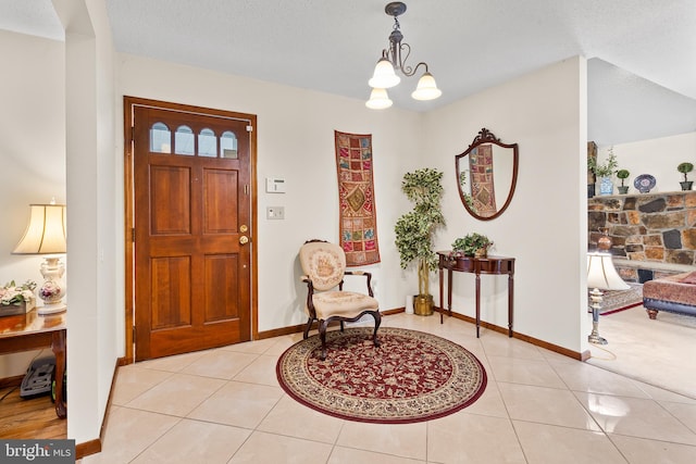 entrance foyer with a notable chandelier, light tile floors, and a textured ceiling