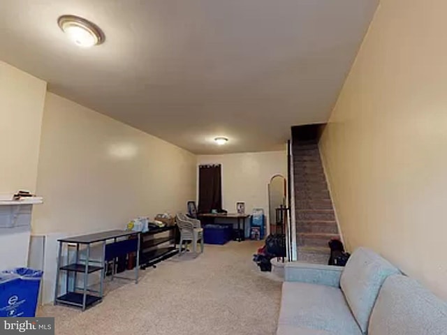 carpeted living room with brick wall