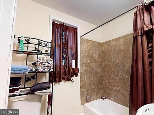 bathroom with shower / bath combination with curtain and toilet